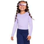 A young girl with bubble braided hair wearing a light purple long-sleeve crewneck shirt, purple sunglasses, and navy blue pants, standing against a solid white background.