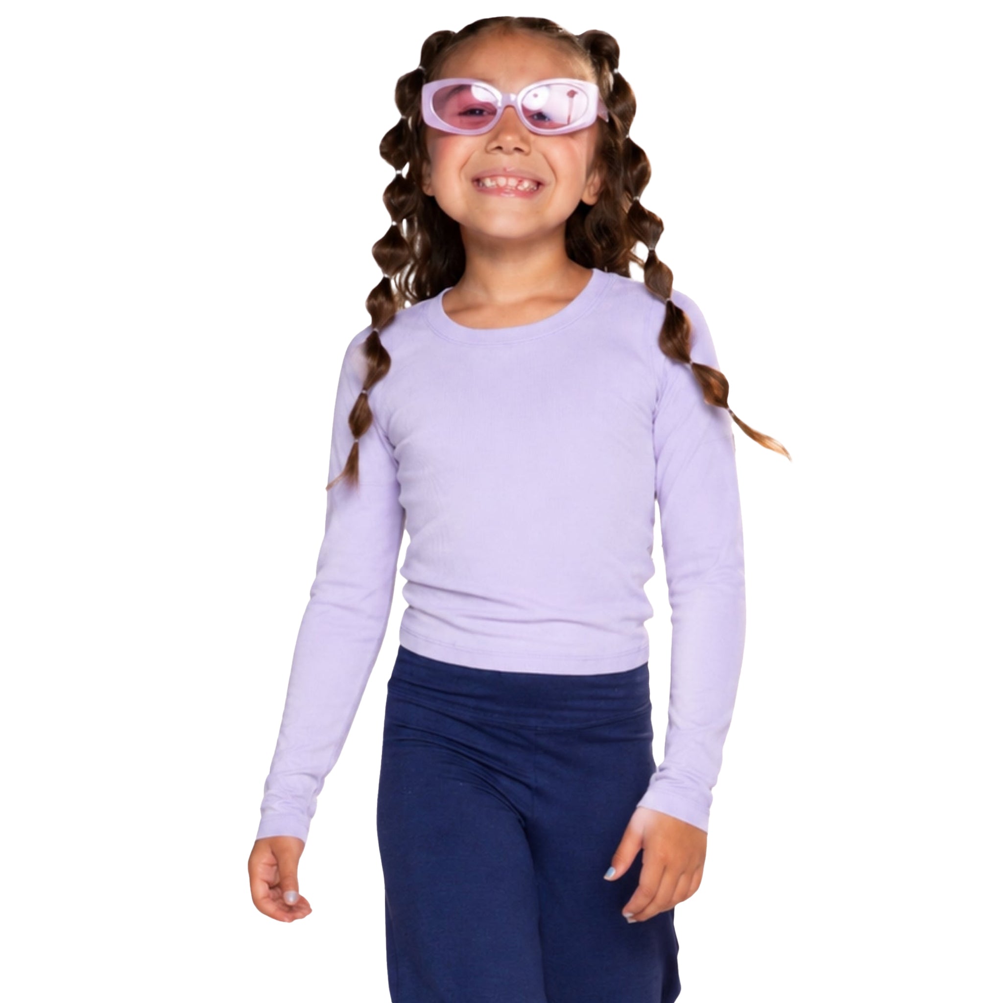 A young girl with bubble braided hair wearing a light purple long-sleeve crewneck shirt, purple sunglasses, and navy blue pants, standing against a solid white background.