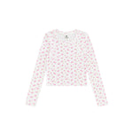 A long-sleeve crop top with a white base and a small pink floral pattern, laid flat against a solid white background.