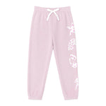 Light pink sweatpants with a white drawstring waist, elastic cuffs, and white printed graphics of stars, rainbows, and sparkles down one leg.