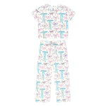 A two-piece baby pajama set featuring a short-sleeve top and matching pants in white, decorated with an all-over pattern of colorful bows in light blue and lavender purple.