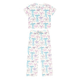 A two-piece baby pajama set featuring a short-sleeve top and matching pants in white, decorated with an all-over pattern of colorful bows in light blue and lavender purple.