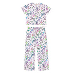 A two-piece children's pajama set featuring a short-sleeve top and matching pants, both in a light pink color with a colorful pattern of cherries, bows, stars, and hearts, displayed on a solid white background.