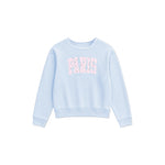 A light blue long-sleeve crewneck sweatshirt featuring the word 'PARIS' printed across the chest in pink floral letters, displayed on a clean white background.
