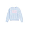 A light blue long-sleeve crewneck sweatshirt featuring the word 'PARIS' printed across the chest in pink floral letters, displayed on a clean white background.