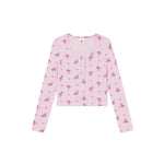 A light pink long-sleeve cropped henley top with a small pink and purple floral pattern, displayed flat against a solid white background.