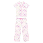 A two-piece girls' pajama set featuring a short-sleeve button-front top and matching pants, both in a white fabric with a small purple floral print and pink piping details.