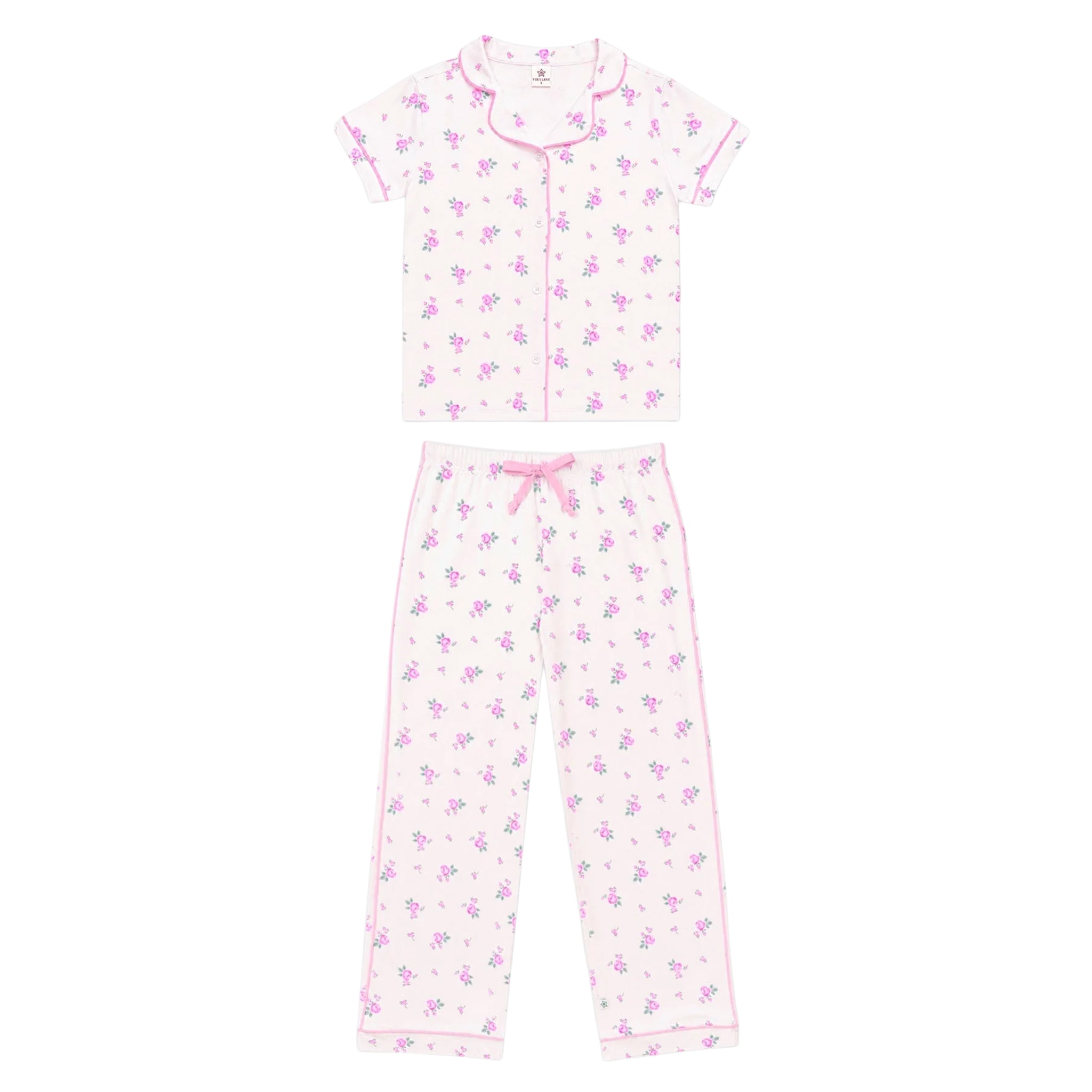 A two-piece girls' pajama set featuring a short-sleeve button-front top and matching pants, both in a white fabric with a small purple floral print and pink piping details.