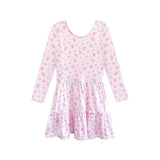 A long-sleeve babydoll dress with a tiered skirt, featuring a light pink base with a dense all-over floral print in pink, green, and white.