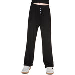 Black wide-leg lounge pants with a three-button placket, shown on a model from the waist down wearing white sneakers against a white background.