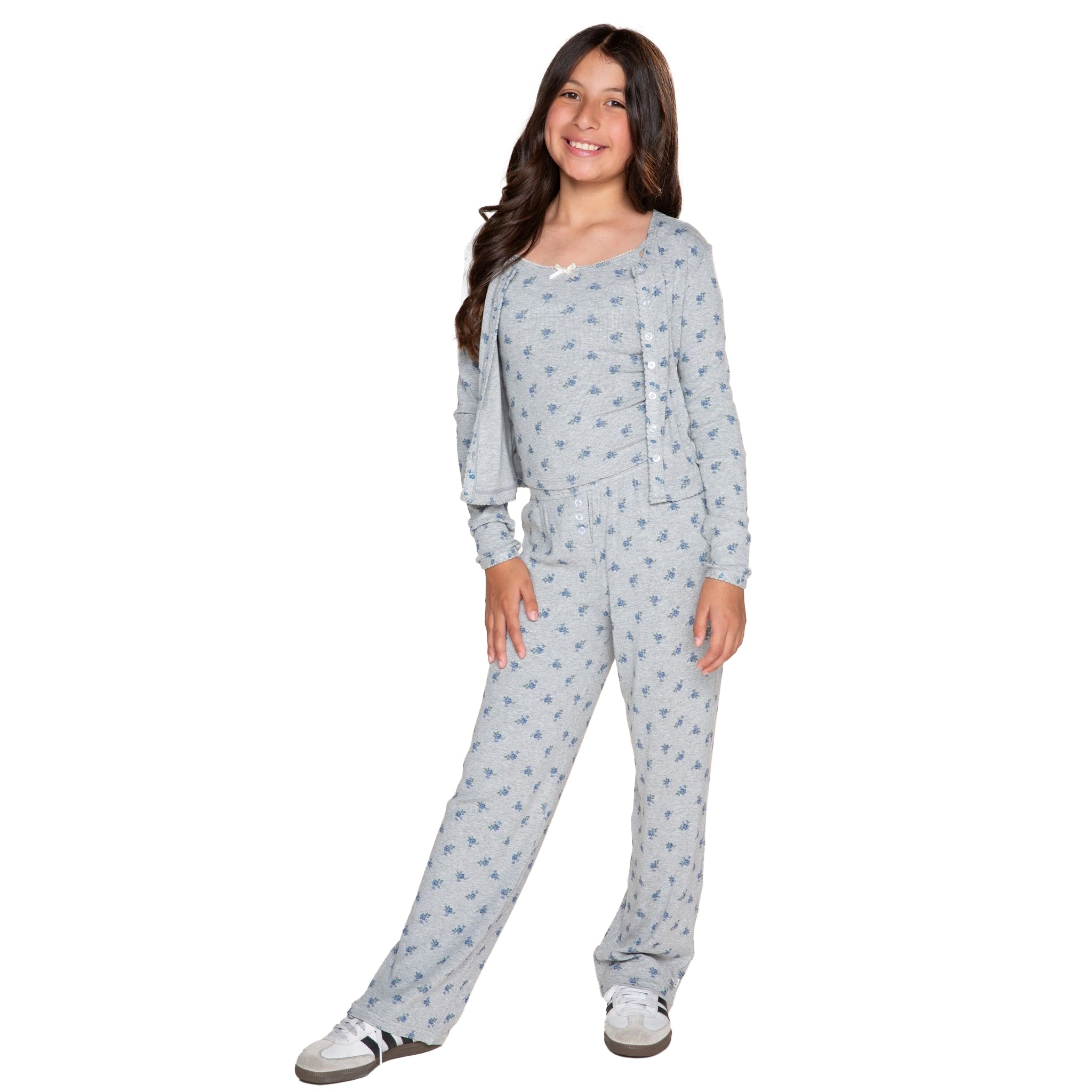 A young girl modeling a grey and blue floral patterned three-piece set, consisting of a cami, long-sleeve top with a button-up front and matching drawstring pants, against a plain white background.