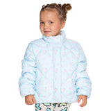 A young girl with her hair in two buns wearing a light blue quilted puffer jacket with a pink floral pattern, photographed against a solid white background.
