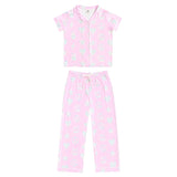A two-piece girls' pajama set in light pink, featuring a short-sleeve button-front top and matching long pants, both decorated with a small white and light blue floral pattern.