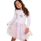 A young girl smiling and wearing a light lavender long-sleeve top with a silver sequined star on the chest, paired with a fluffy pastel tulle skirt covered in silver star sequins, set against a plain white background.