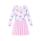 A girls' long-sleeve dress in light pink with an allover bow print in pastel shades of blue, purple, and green, featuring a gathered tulle skirt.