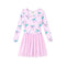 A girls' long-sleeve dress in light pink with an allover bow print in pastel shades of blue, purple, and green, featuring a gathered tulle skirt.