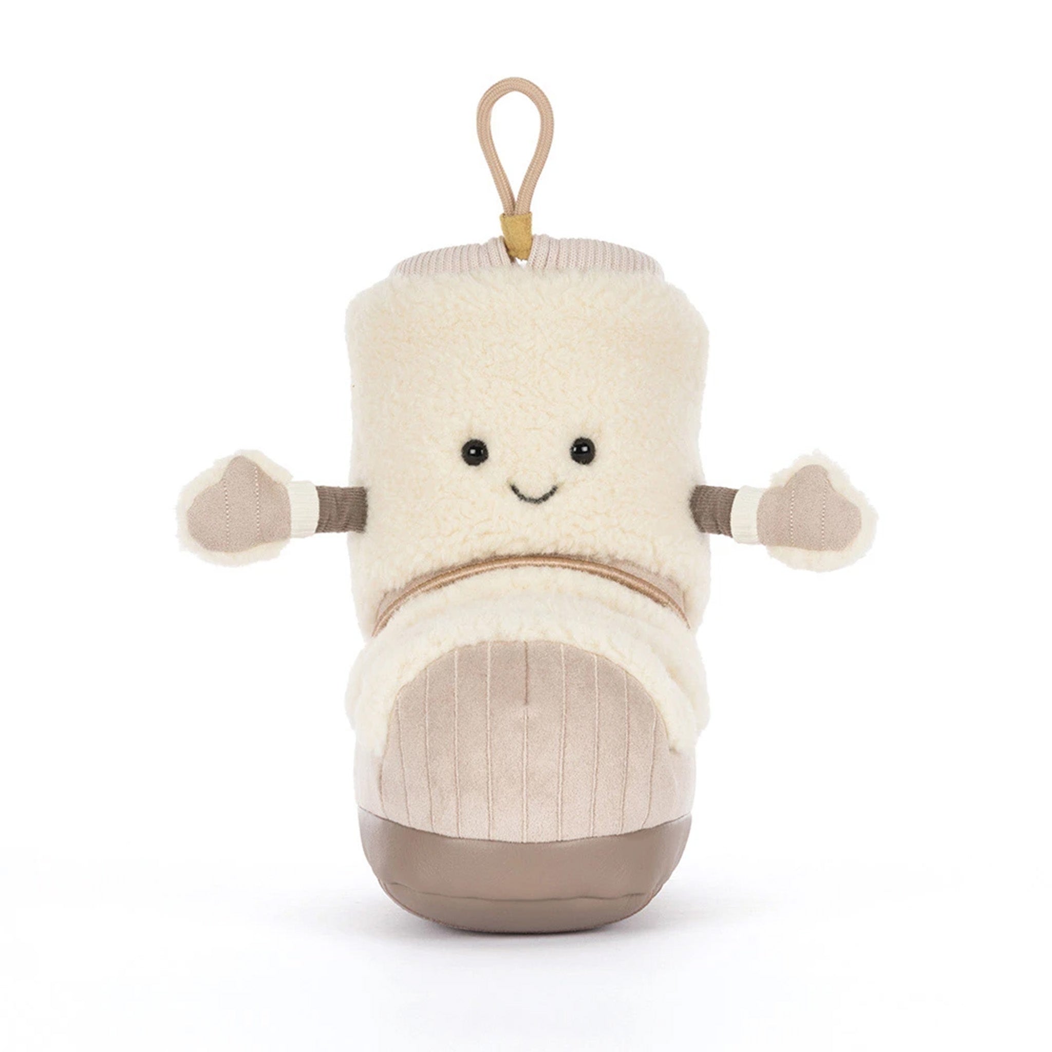 A plush toy shaped like a boot or shoe, made from cream-colored faux fur with a beige corduroy-textured lower section, brown accents on the soles and arm cuffs, and a small tan hanging loop at the top. It has a simple embroidered smiley face.