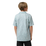 A child model shown from the back wearing a light blue short-sleeve collared shirt with a white abstract pattern, paired with black pants, against a plain white background.