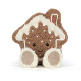 A gingerbread house plush toy with a brown textured body, cream-colored icing, embroidered facial features, and soft cream paws, photographed on a clean white background.