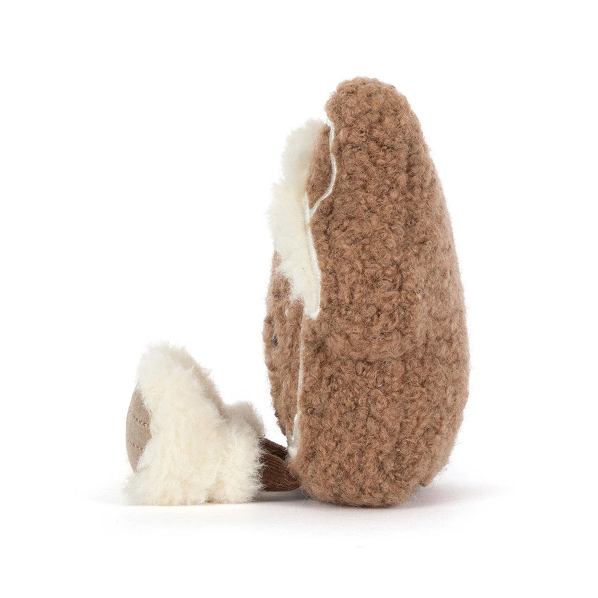 A brown textured plush character, shown from the side on a clean white background. The toy features a fluffy cream-colored inner lining and a small matching cream tail.