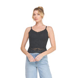 A woman modeling a black lace camisole tank top with thin straps and a scalloped neckline, paired with light blue jeans, against a plain white background.