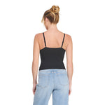 A woman shown from the back wearing a black spaghetti-strap camisole top and light blue jeans against a plain white background.