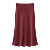 A satin slip skirt in a deep burgundy red, displayed against a solid white background.