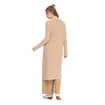 A woman shown from the back wearing a long beige knit turtleneck cardigan with matching wide-leg pants and white boots, set against a plain white background.