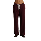 A person wearing burgundy wide-leg sweatpants with a white drawstring, shown from the waist down against a plain white background.