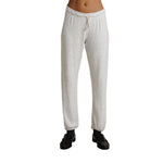 A person wearing light heather gray sweatpants with a drawstring waistband and black shoes, shown from the waist down on a plain white background.