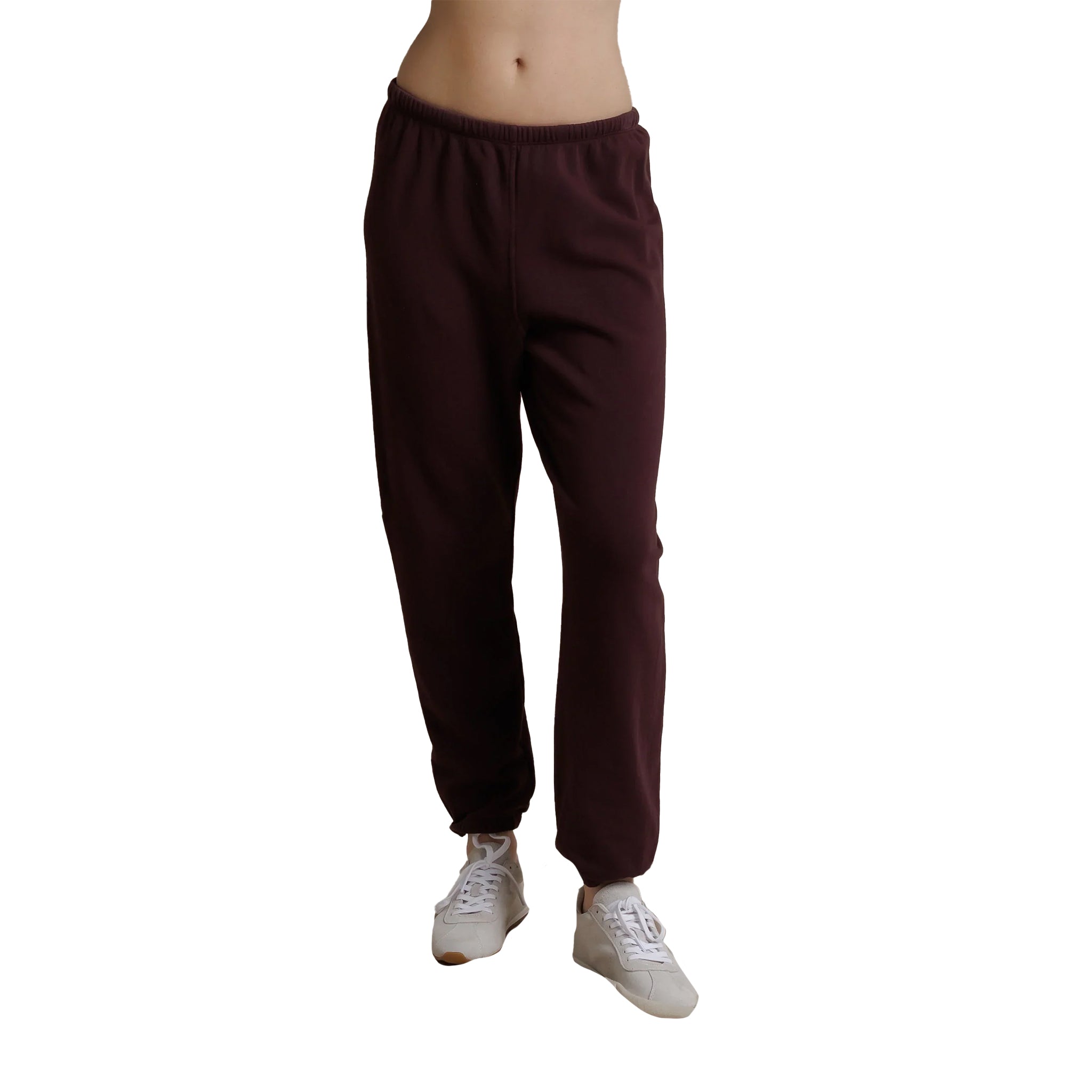 A person wearing dark burgundy jogger sweatpants and white sneakers, cropped from the waist down, shown against a plain white background.