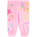 Pink jogger pants for kids featuring a colorful all-over print of smiley faces, hearts, flowers, and stars, shown flat on a white background.