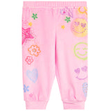 Pink jogger pants for kids featuring a colorful all-over print of smiley faces, hearts, flowers, and stars, shown flat on a white background.