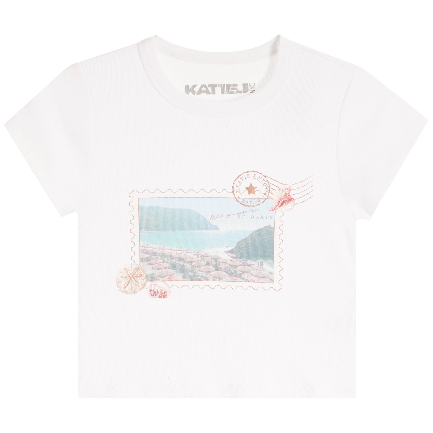 A white short-sleeve crewneck t-shirt by Katie J, featuring a vintage postage stamp graphic on the front with a coastal landscape, shells, and a stamp cancellation mark.
