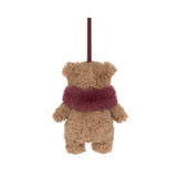 A small plush teddy bear ornament or hanging decoration in warm tan with a fuzzy burgundy scarf and a matching hanging loop, shown on a plain white background.
