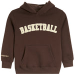 A dark brown pullover hoodie with 'BASKETBALL' printed in cream arched letters across the chest and a small matching print on the left sleeve cuff, shown against a plain white background.