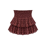 A tiered ruffle mini skirt in a dusty rose-brown color with a small pink floral pattern, featuring a smocked elastic waistband, shown against a plain white background.