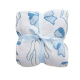 A folded white plush towel or blanket with a blue abstract pattern, tied with a light blue ribbon bow, on a plain white background.