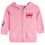 A pink zip-up hoodie for toddlers, featuring a large pink bow graphic on the left chest, a blue and white patterned patch on the right sleeve, and two front pockets with decorative stud details.