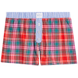 A pair of boxer shorts featuring a vibrant red, pink, and green plaid pattern on the body, a light blue and white striped waistband, and a three-button front closure.