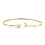 A thin gold bangle bracelet with an open end featuring a small star charm and the other end featuring a small crescent moon charm, displayed on a clean white background.
