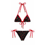 Black bikini set with red accents and floral pattern on a white background