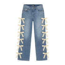 Light blue denim jeans with cream lace bow embellishments attached along both outer legs, shown flat against a white background.