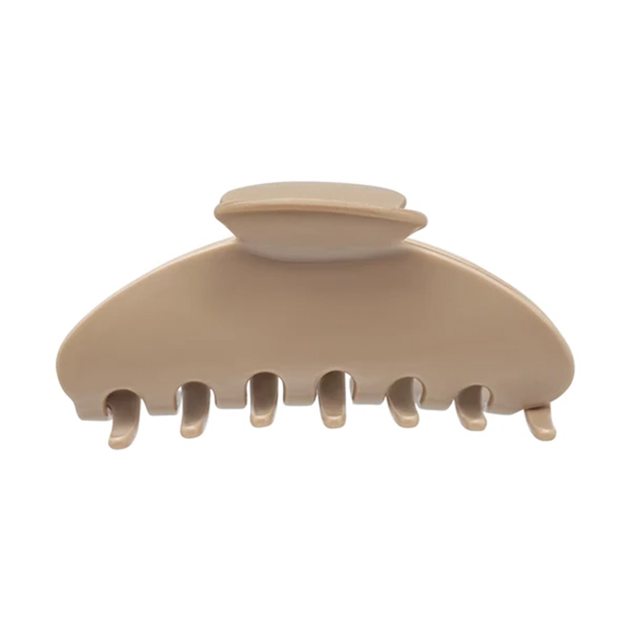 A single hair claw clip in a warm beige or cream color, photographed from a top-down angle on a solid white background.