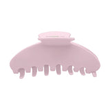 A light pink plastic claw hair clip on a solid white background.