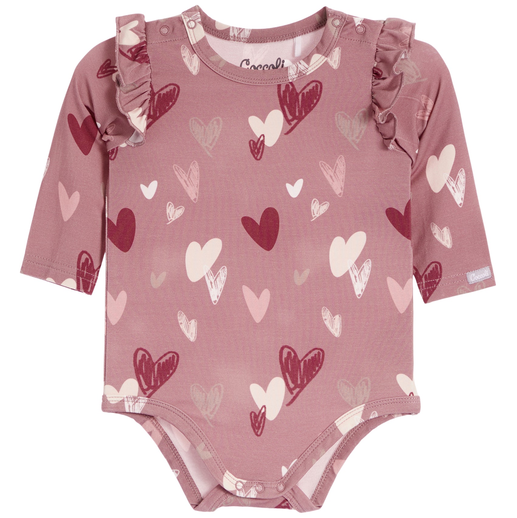 A dusty rose pink long-sleeve baby bodysuit with an all-over heart pattern in shades of red, pink, and white, featuring ruffle details on the shoulders and snap closures at the crotch and neckline.