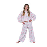 A young girl modeling a matching two-piece pajama set featuring a white base with a pink bow and gray floral pattern, set against a plain white background.