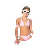 Girl wearing a pink bikini and white sunglasses on a white background