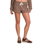 A model wearing leopard-print shorts with a white drawstring and a matching long-sleeve top, paired with brown and gold sneakers, shown against a plain white background.