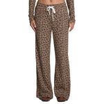 A person wearing leopard-print lounge pants with a white drawstring, shown from the waist down against a plain white background.